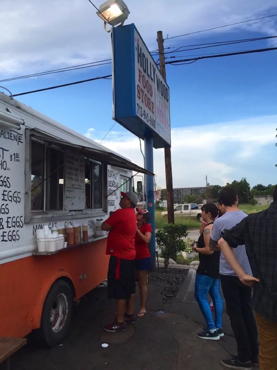 A line of regulars ordering at the Tacos Tierra Caliente truck at dusk in Montrose